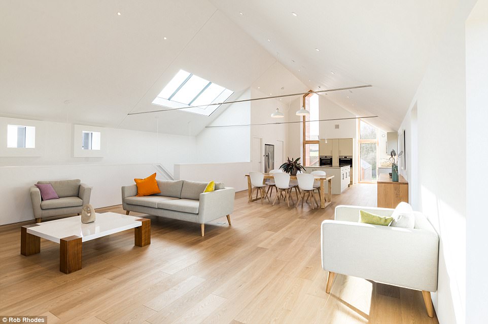 New perspective: The ground floor has three bedrooms and a utility room while the top floor features an enormous open plan kitchen and living area, pictured. The unconventional layout means the upstairs living quarters benefit from additional space and height, not to mention the inspiring vista visible from the large windows, seen at the back of the room above