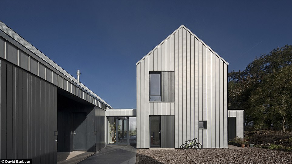 Modern twist: In Ayrshire, retired GP Mike Law and his wife Sally spent £600,000 building the Newhouse on old farm land at Auchengree, which they styled to look like an updated barn. The farmhouse style is functional as well as striking