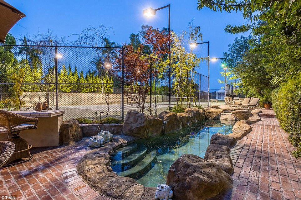 All the amenities: The home comes complete with a scenic pond style pool and tennis court