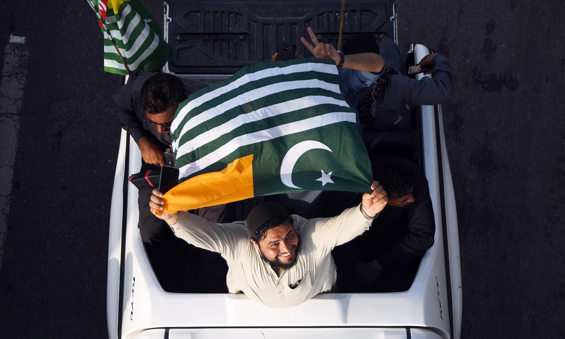 A man waves an AJK flag as he takes part in Independence Day celebrations in Karachi. — AFP