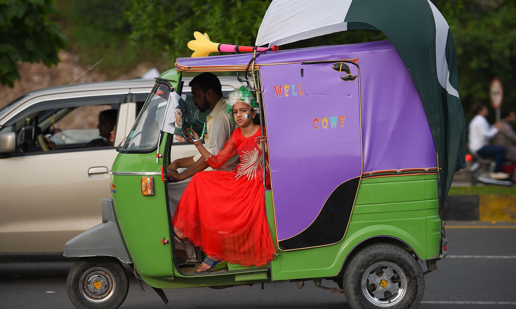 A young girl looks on from an auto-rickshaw as she takes part in Independence Day celebrations in Islamabad. — AFP