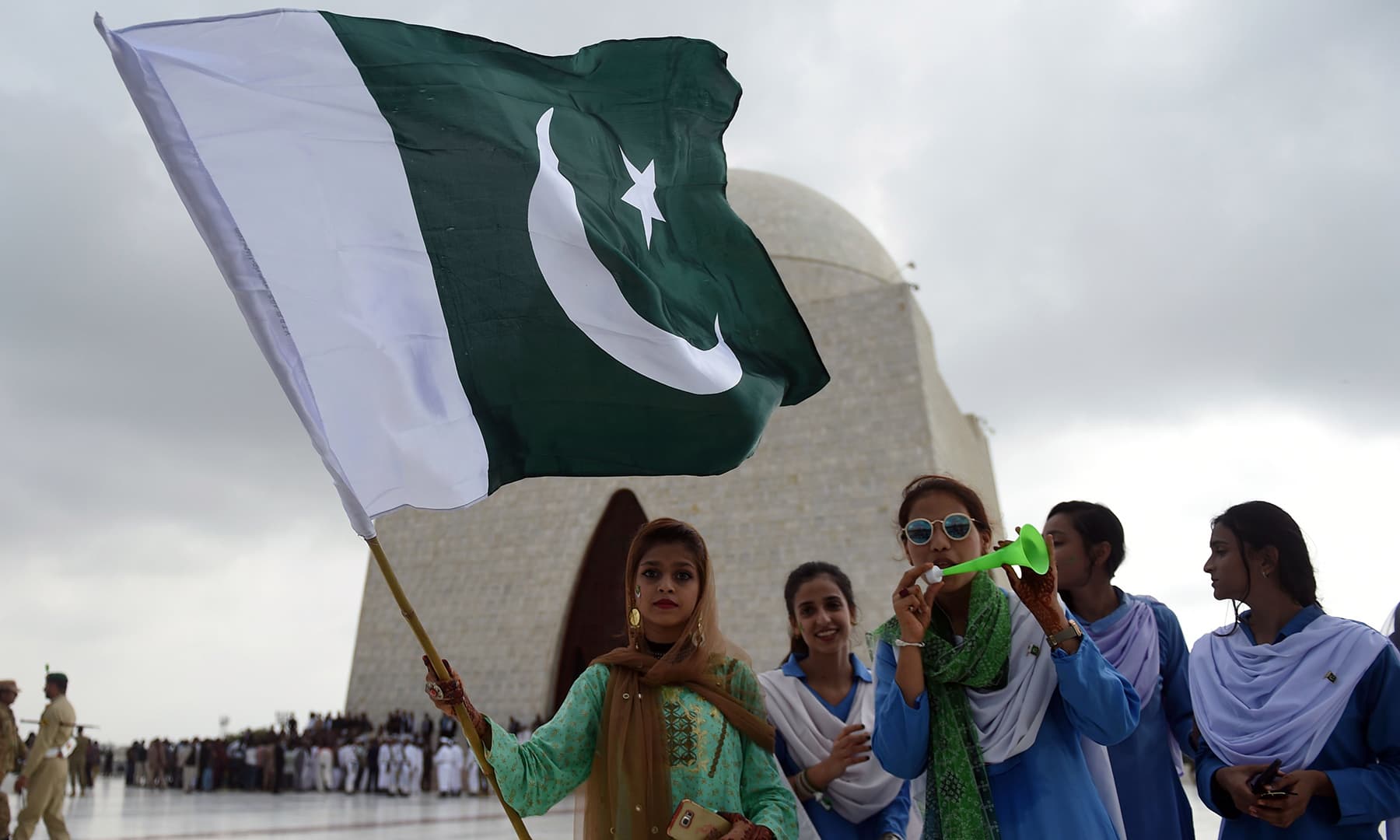 Girls hold a national flag in front of the mausoleum of founding father Quaid-i-Azam Muhammad Ali Jinnah during Independence Day celebrations in Karachi on August 14. — AFP