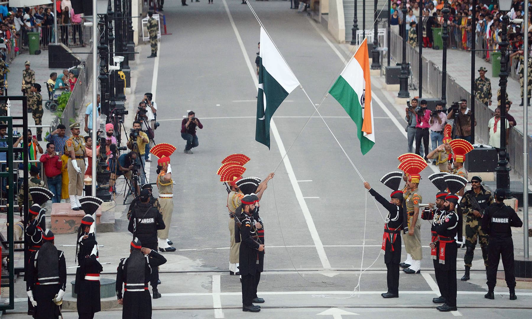 Pakistani Rangers and Indian Border Security Force personnel take part in the flag-lowering ceremony at Wagah border. — AFP