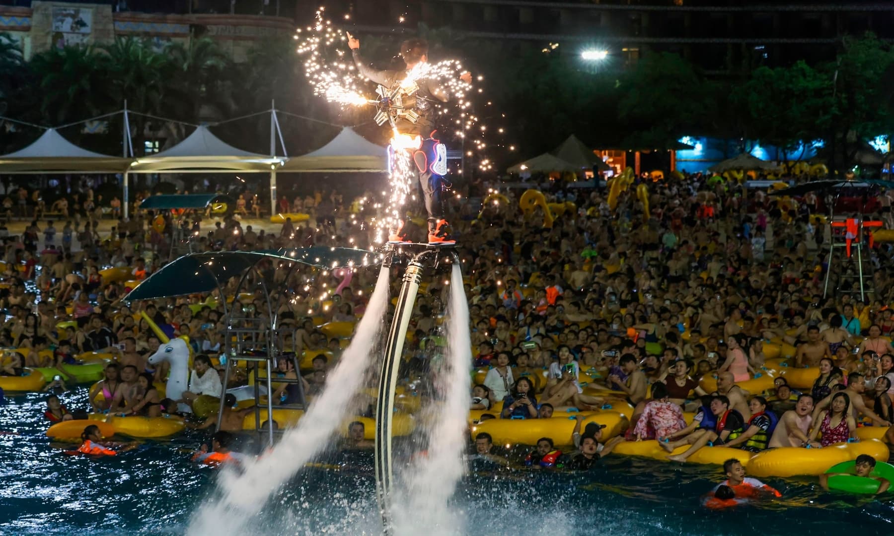 This photo taken on August 15, 2020 shows people watching a performance as they cool off in a swimming pool in Wuhan in China's central Hubei province. — AFP