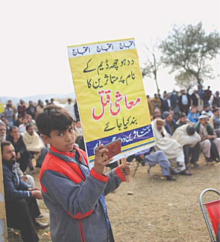 A child holds up a sign at a protest being staged by Daducha Dam affectees | Sibte Hassan Turi