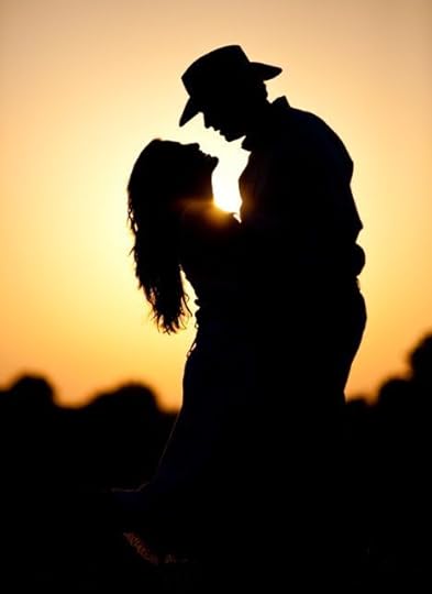 silhouette of cowboy kissing woman