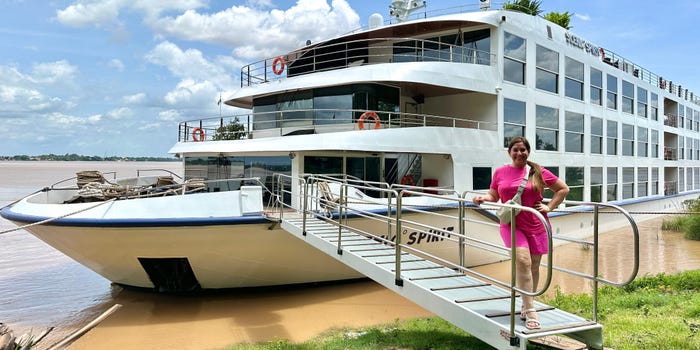 Author Jill Schildhouse standing outside of small river cruise ship while docked 