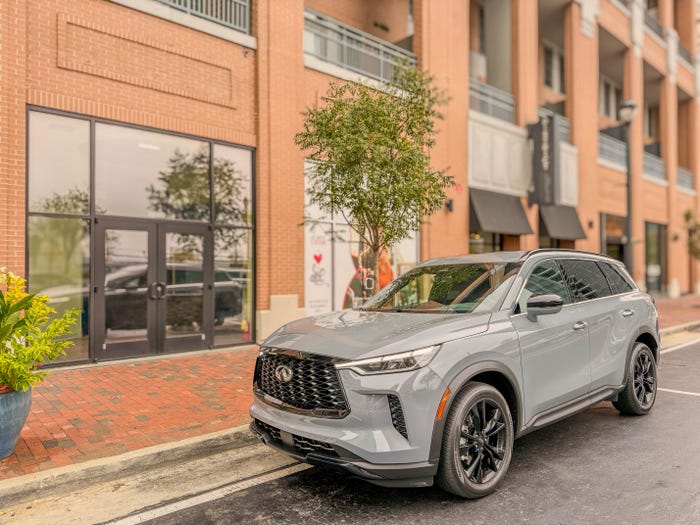 The left front of a gray 2025 Infiniti QX60 Luxe Black Edition SUV parked on the street.