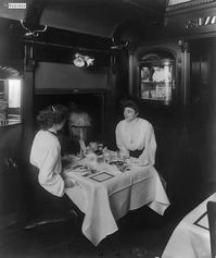 Photograph shows two young women, finished eating, seated at a table in a dining car. Contributor Names Geo. R. Lawrence Co., photographer Created / Published c1905. Retrieved from the Library of Congress, https://www.loc.gov/item/2012649433/.