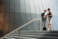 Business people talking at top of steps outdoors