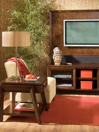 This stylish living room combines elements of nature with Asian design and sculpture. The bamboo wall coverings and lampshade blend well with the decorative head on the entertainment center.