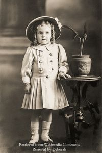 She is wearing a hat and has her hair in ringlets.  From the State Library of Queensland.  {{PD-US-expired}}