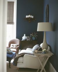 Deep, dark blue walls envelop a room, creating a romantic mood, especially when paired with the soft tones of chalky whites and soft dusky pinks. Homes & Gardens, Photography Tom Leighton