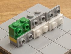 three legos sitting on top of each other in front of a wooden table with white tiles