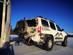 a white truck parked on the side of a snow covered road