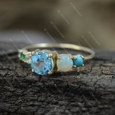 This ring is made with Genuine Sleeping Beauty Arizona Turquoise/ Zambia Emerald/ Blue Topaz & Ethiopian Opal Gemstone & SI Clarity G-H Color Diamond and 14K solid yellow gold * SKU: SGR01148 * Made to Order * Gold Purity: 14K Solid Yellow Gold (stamped) * Custom Gold Color: Rose Gold, Yellow Gold, White Gold * Custom Gold Purity: 9K/14K/18K (Charges Apply) * Diamond 100% Genuine Diamond * Diamond weight: 0.03 ct * Diamond Color: G-H * Diamond Clarity: SI1- SI2 * Diamond Cut: Brilliant C Turquoise Multi-stone Round Opal Ring, Blue Emerald Ring For May Birthstone, Blue Emerald Ring For May Birthstone, Round Shape, Blue May Birthstone Rings, Turquoise Multi-stone Gemstones, Turquoise Multi-stone Round Gemstones, Round Multi-stone Gemstones For May Birthstone, Blue Emerald Birthstone Ring, Blue Three Stone Birthstone Ring