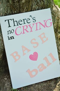 there's no crying in base ball sign next to a tree with pink hearts