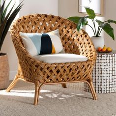 a wicker chair sitting on top of a rug next to a potted plant