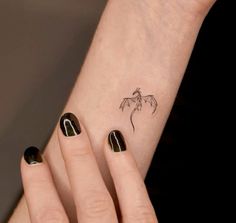 a woman's hand with a small tattoo on it