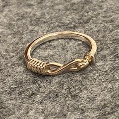 This delicate ring has a squared base shape, and is wrapped at the front with slender coils, resembling a gold string tied around the finger. It is based on a Roman example from the second century AD. "Memoria" is the Latin term for memory, remembrance, and recollection. Ring Details Thickness of shank: 1.7 mm (.07 in) Available Precious Metals and Prices 14 Karat Gold: $250 18 Karat Gold: $380 Adjustable Rings With A Modern Twist For Promise, Adjustable Promise Ring With A Modern Twist, Modern Twist Adjustable Promise Ring, Gold Sterling Silver Rings With A Modern Twist, Elegant Adjustable Hand-wrapped Rings, Adjustable Infinity Stackable Rings With A Modern Twist, Silver Infinity Ring In 14k Gold, Sterling Silver Infinity Ring In Yellow Gold, Adjustable Spiral Yellow Gold Ring