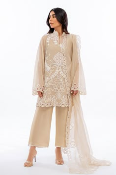 An ethereal sand coloured khaddi corduroy shirt is rendered with bold ivory dori embroidery. Eyelet details on scalloped edges are featured on the shirt as well as on the matching organza dupatta. Complete the look with our signature rawsilk culottes accented with embroidered details. Culottes Outfit Indian, Organza Pakistani Suits, Pakistani Organza Suits, Organza Suits Indian, Ivory Dress Outfit, Organza Suit Design, Heavy Embroidery Dupatta, Kurta Set With Dupatta, Dupatta Designs