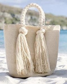 Our cute Summer Tote Bags with long Tassels are the perfect addition to your Summer wardrobe in Boho Chic Style. Stand out wearing a fashionable Tote Bag In the crook of your elbow or on your shoulder. Lightweight, durable and machine washable, this stunning tote beach bag is the perfect accessory for every day, a getaway, or poolside/beach day! Details: 4 Long Tassels (bags look the same on the back) Hand-crocheted using double thread crochet and one needle technique Hand-braided Strap. Materia Diy Beach Bag, Crochet Mini Bag, Boho Chic Bags, Crochet Beach Bags, Boho Tote Bag, Tote Beach Bag, Crochet Bag Pattern Free, Summer Tote Bags, Summer Tote