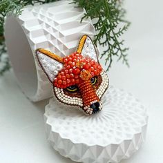 Surprise someone special with this quirky handmade beaded fox brooch! Crafted with care, this adorable fox face is brought to life with vibrant beads and shimmering crystals. A one-of-a-kind gift that will bring a smile to any nature or animal lover's face. This brooch is perfect for those who appreciate artistic, boho-inspired accessories. Whether it's for a birthday, a holiday, or just because, this unique piece adds a playful touch to any outfit. Its lightweight design makes it comfortable to wear, and the intricate beadwork ensures that it will be admired by all. Care instructions: Avoid water, perfumes, and chemicals to keep your brooch looking as stunning as the day you bought it. Store in a cool, dry place. Custom orders and wholesale: Looking for a personalized version? Or maybe yo Surprises For Her, Boho Accessories, Artisan Gift, Handmade Beaded Jewelry, Quirky Gifts, Brooches Handmade, Beaded Brooch, Boho Stil, Surprise Gifts