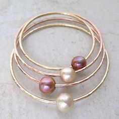 "Edison Pearl Bangle~ Elegant bangle with a beautiful Edison pearl, hammered and polished for that extra sparkle! Pearl approx. 10-11mm. Pearls vary in color Made with thick 12 g. your choice of 14k yellow or rose gold fill. SIZES~ extra small - 7\" small - 7.5\" Medium - 8\" Large - 8.5\" Extra large - 9\" For correct sizing measure the circumference of your hand around the largest part of your hand under your thumb and pinky joint with your thumb tucked in towards pinky finger, fingers out str Elegant Hand Forged Bangle, Adjustable Hammered Wedding Bangle, Adjustable Hammered Bangle For Wedding, Bangle Jewelry For Bridesmaid Gift, Hand Forged Bangle For Wedding, Hammered Bangle Bracelet For Anniversary, Pearl Bangles Gold, Surfer Girl Gifts, Tahitian Pearl Ring