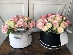 two black and white buckets with pink roses in them