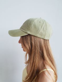 a woman with long hair wearing a green hat