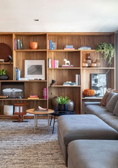 a living room filled with furniture and bookshelves next to a wall mounted tv