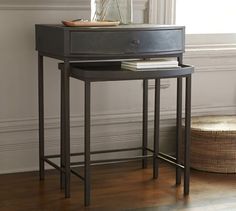 a black table with two drawers and a basket on the floor in front of it