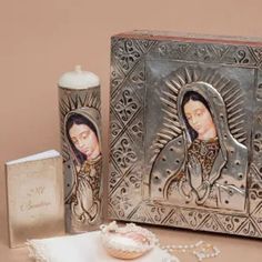 an image of the virgin mary and baby jesus on a box next to a candle