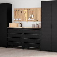 a kitchen with black cabinets and drawers in it's center, next to a white wall