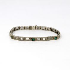 Phenomenal antique Art Deco Era 14k white gold filigree simulated emerald bracelet! This piece features three square cut bezel set simulated emerald stones (garnet glass doublets - very common of this time period). The dainty bracelet's panels are detailed with intricate pierced filigree with sweet flower motifs. There is a filigree clad box clasp closure. A gorgeous piece of fine jewelry, circa 1920s! Such a detailed and stunning bracelet from the roaring '20s, which would make a lovely bridal piece!  ERA - Circa 1920, Art Deco Era METAL / MATERIAL - 14k white gold, three simulated emeralds (garnet glass doublets) MARKINGS / HISTORY - Clasp is stamped 14k CONDITION - Good vintage condition. Designs are beautifully preserved. Piece has been professionally cleaned and lightly polished. Ston Vintage White Gold Hand-set Bracelets, Art Deco Hallmarked White Gold Bracelets, Vintage White Gold Diamond Jubilee Bracelet, Art Deco Hallmarked White Gold Bracelet, Art Deco Hallmarked Bracelet For Anniversary, Vintage Formal Diamond Bracelet With Hand Set, Vintage Diamond Bracelet With Hand Set For Formal Occasions, Vintage White Gold Diamond Bracelet, Vintage Hand Set Diamond Bracelet For Formal Occasions