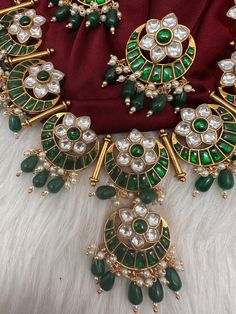 Jadau Kundan Green Floral Necklace with matching EarringsColor : GoldenSize : Necklae Length : 16 Inches; Earrings Length : 1.5 InchesStones : Jadau Kundan Pearls Traditional Festival Earrings With Stones, Traditional Round Kundan Necklace With Stones, Traditional Kundan Necklace For Celebration, Temple Jewelry Sets With Stones For Festive Occasions, Festive Temple Jewelry Sets With Stones, Festive Kundan Necklace With Stones, Traditional Kundan Necklace With Matching Earrings For Celebration, Kundan Bridal Necklace With Matching Earrings In Temple Style, Festive Traditional Earrings With Stones