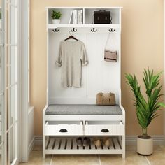 a room with a bench, potted plant and coat rack