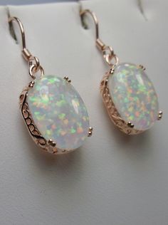 Simulated Opal Earrings Description Edward Design#70 Made to Order These are Edwardian reproduction earrings in sterling silver and rose gold (also available in sterling silver without plating, yellow gold plated, or even 10/14k solid gold) set with stunning simulated rainbow Opal gemstones. Each stunning simulated oval cabochon Opal is 14mm long (9/16th") and 10mm in width (3/8th"). The earrings are 1 and 3/4th inches long. Notice the beautiful swirl and etched filigree of the setting. These lo Engraving Jewelry, Art Deco Filigree, Edwardian Ring, Antique Filigree, Order Design, Filigree Jewelry, Edwardian Art, Earrings Rose Gold, Filigree Earrings