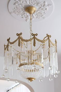 a chandelier hanging from the ceiling in a room with white walls and ceilings