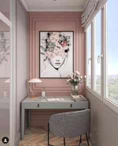 a room with a desk, chair and large painting on the wall in pink tones