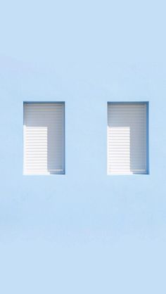 two windows with white blinds are shown against a light blue wall, one is open and the other is closed