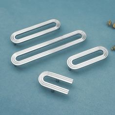 three metal handles on a blue surface with screws