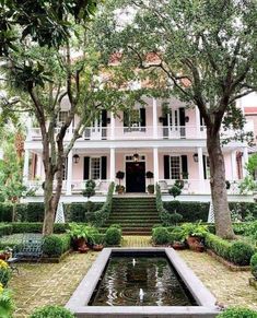 a large white house surrounded by trees and bushes