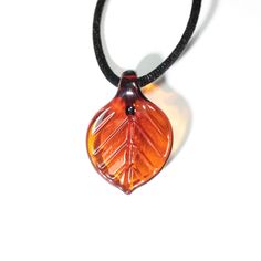 Perfect for the lover of nature and natural things, our Leaf Pendants are simple beauty. Lightweight and colorful, these pendants can match your favorite season or your favorite color. This simple yet fresh leaf pendant should be added to your necklace collections. Nodding our hats to the seasons spring, summer, and fall; we offer Red, Amber, Gold, Green, Teal, Blue, Lavender, or Pink. Leaf Pendants come with a simple black satin cord. Approximately 1.5" - 2" long Made in the Flamework studio in Natural Things, Blue Lavender, Our Environment, Simple Beauty, Leaf Pendant, Favorite Season, Simple Elegance, The Natural World, The Seasons