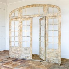 an open door in the middle of a room with wooden flooring and white walls