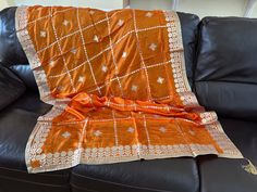 Discounted from $65.07. This is a soft, orange silk shawl scarf stole.  It has gold lace (called gota in Hindi) applique in intrinsic floral motifs throughout the wrap. Applique is sewn to the fabric so it doesn't fall off with use. All four edges have intricate sewn, gold applique as well. There are pasted stones all over the dupatta that further enhance its beauty. One tassel is on each short edge (a total of two on a dupatta).  This is a handcrafted work of wearable art. So beautiful! MATERIA Festive Orange Silk Dupatta, Orange Silk Traditional Wear With Dupatta, Silk Dupatta With Zari Work In Orange, Festive Orange Katan Silk Dupatta, Orange Katan Silk Dupatta For Eid, Orange Banarasi Silk Dupatta With Self Design, Bollywood Orange Dupatta For Eid, Orange Self-design Dola Silk Dupatta, Traditional Orange Wear With Dupatta