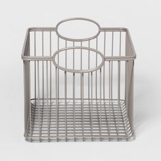 a metal basket with a circular handle on the top and bottom, sitting in front of a white background