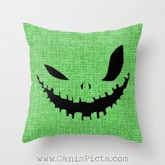 a green pillow with an evil face drawn on it