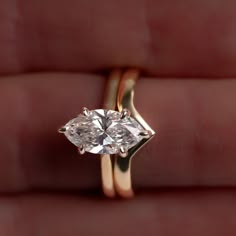 a close up of a person holding a ring with a diamond