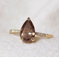 a fancy ring with a pear shaped brown diamond